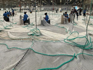 Circular fish farming pond with netting in aquaculture facility.