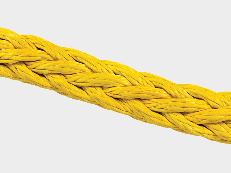 Close-up of a yellow braided rope, durable and strong for industrial use.