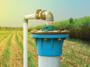 Water pump with pipe in agricultural field for industrial safety.