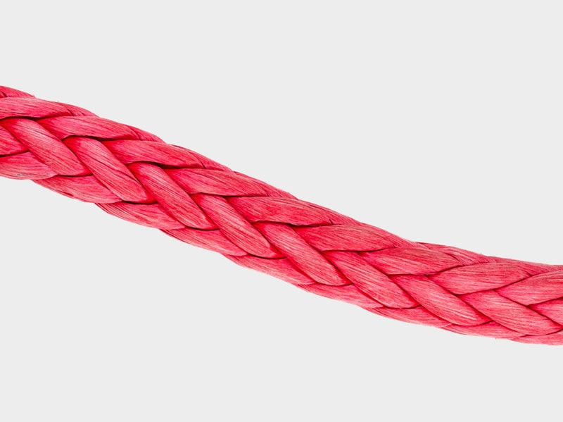 Close-up of red braided rope fiber, detailed texture and weave.