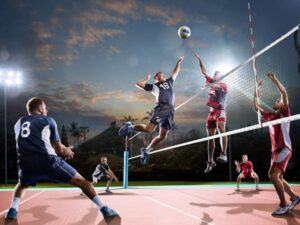 Volleyball players in action during a match at sunset with mountains in background.